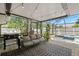 Inviting screened porch with comfortable seating, an outdoor grill, and a view of the pool at 2353 Eastwood Dr, Clearwater, FL 33765