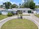 Aerial view of a single-story home with a circular driveway and a green lawn at 2502 Tropical Shores Se Dr, St Petersburg, FL 33705