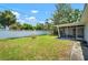 Spacious backyard with a white fence, a covered patio, and well-maintained green lawn for outdoor enjoyment at 2502 Tropical Shores Se Dr, St Petersburg, FL 33705