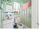 Small bathroom features a toilet, sink, mirror, and a shower with blue accents at 2502 Tropical Shores Se Dr, St Petersburg, FL 33705