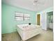 Light-filled bedroom with a bed, window, mint-green walls, and access to a bathroom at 2502 Tropical Shores Se Dr, St Petersburg, FL 33705