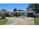Inviting single-story home featuring a lush front yard and attached garage at 2502 Tropical Shores Se Dr, St Petersburg, FL 33705