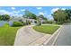 Charming single-story home with a circular driveway and a well-manicured front lawn with green garage door at 2502 Tropical Shores Se Dr, St Petersburg, FL 33705