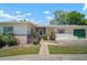 Charming single-story home with brick accents, a green garage door, and a well-manicured lawn at 2502 Tropical Shores Se Dr, St Petersburg, FL 33705