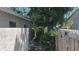 View of the side yard with wood and concrete fences and mature trees at 2502 Tropical Shores Se Dr, St Petersburg, FL 33705