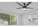 A bedroom with a ceiling fan and two windows showcasing a peaceful view at 2701 Camellia Ter, Punta Gorda, FL 33950
