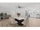Open-concept dining room with modern light fixture and view to the kitchen with stainless appliances at 2701 Camellia Ter, Punta Gorda, FL 33950