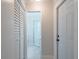 Hallway leading to the bathroom, with a closet on the left and a closed door on the right at 2701 Camellia Ter, Punta Gorda, FL 33950