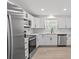 Bright kitchen featuring stainless steel appliances, white cabinetry, and light wood flooring at 2701 Camellia Ter, Punta Gorda, FL 33950