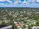 Scenic aerial view of the property surrounded by lush trees and a tranquil lake in a serene neighborhood at 296 Huntington Dr, Largo, FL 33771