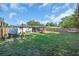 Spacious backyard with green grass, a wooden fence, and a screened-in patio at 296 Huntington Dr, Largo, FL 33771