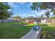 Large backyard with lush green grass, a hammock, and a wooden fence at 296 Huntington Dr, Largo, FL 33771