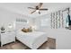 Bright bedroom featuring a ceiling fan, a large window, and decorative vines on the wall at 296 Huntington Dr, Largo, FL 33771