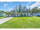 Charming single-story home with a well-manicured lawn, carport, and inviting curb appeal at 296 Huntington Dr, Largo, FL 33771