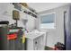 Laundry room with a washer, a dryer, a water heater, and shelving at 296 Huntington Dr, Largo, FL 33771