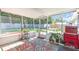 Screened in patio with plants and a colorful rug overlooking a big backyard at 296 Huntington Dr, Largo, FL 33771