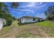Home's lush backyard with a partial view of the house and fence at 3009 Ainsworth Ave, Spring Hill, FL 34609