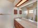 Traditional bathroom featuring wood cabinets, large mirror and shower at 3009 Ainsworth Ave, Spring Hill, FL 34609