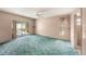 Bedroom with turquoise carpet and access to screened-in pool and bathroom at 3009 Ainsworth Ave, Spring Hill, FL 34609