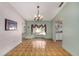 Sunlit dining room featuring parquet floors, elegant chandelier and a bay window at 3009 Ainsworth Ave, Spring Hill, FL 34609