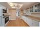 Kitchen featuring white appliances, wood cabinets, and laminate floors with a skylight at 3009 Ainsworth Ave, Spring Hill, FL 34609