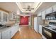 Kitchen featuring white cabinets, laminate floors, and modern appliances at 3009 Ainsworth Ave, Spring Hill, FL 34609