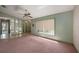 Spacious living room with large window, mirrored wall, neutral carpeting and ceiling fan at 3009 Ainsworth Ave, Spring Hill, FL 34609