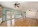 Bright living room with parquet floors and double doors leading to an outdoor pool area at 3009 Ainsworth Ave, Spring Hill, FL 34609