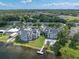 Aerial shot of lakeside condos with pool and dock, surrounded by lush greenery at 3127 W Sligh Ave # 101C, Tampa, FL 33614