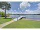 A serene wooden dock on a lush, green waterfront property against a blue sky at 3127 W Sligh Ave # 101C, Tampa, FL 33614
