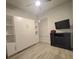 Clean bedroom featuring light floors, a large murphy bed, and a modern ceiling fan and entertainment center at 3127 W Sligh Ave # 101C, Tampa, FL 33614