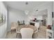 Bright dining area features a round table with chairs and a modern chandelier adjacent to an open concept kitchen at 3127 W Sligh Ave # 101C, Tampa, FL 33614