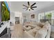 Bright living room featuring a large sectional sofa, fireplace, and serene backyard views at 3127 W Sligh Ave # 101C, Tampa, FL 33614