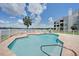 Community swimming pool with lounge furniture and a scenic view of the lake at 3127 W Sligh Ave # 101C, Tampa, FL 33614