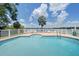 Enjoy a beautiful, private outdoor pool with brick patio, white fence, and lake views at 3127 W Sligh Ave # 101C, Tampa, FL 33614