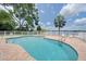 Inviting pool area with a white fence, brick pavers, and views of the water at 3127 W Sligh Ave # 101C, Tampa, FL 33614