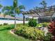 Beautiful backyard features a pergola, fire pit, palm trees and lush landscaping at 3503 Graycliff Ln, Brandon, FL 33511