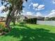 Green grass and large trees in the backyard of this single-Gathering home featuring a white fence at 3503 Graycliff Ln, Brandon, FL 33511