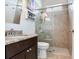 Modern bathroom featuring a granite countertop, dark cabinets, and tiled shower with glass door at 3503 Graycliff Ln, Brandon, FL 33511