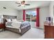 Comfortable bedroom featuring a large window with view, a ceiling fan, and wood furniture at 3503 Graycliff Ln, Brandon, FL 33511