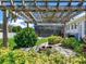 Charming backyard fire pit area under a pergola with a pool in the background at 3503 Graycliff Ln, Brandon, FL 33511