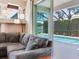 Open living room with a comfortable couch and sliding glass doors leading to a screened pool area at 3503 Graycliff Ln, Brandon, FL 33511