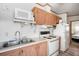 Functional kitchen with white appliances, wood cabinets, double sink, and wood-look flooring at 35045 Cynthia Ave # 35945, Zephyrhills, FL 33541