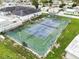 Overhead view of a tennis court with an adjacent building and several chairs and benches at 35045 Cynthia Ave # 35945, Zephyrhills, FL 33541