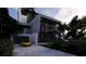 Modern home showcasing a striking design with a yellow sports car in the driveway and lush landscaping at 3611 Bayshore Ne Blvd, St Petersburg, FL 33703