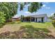 Large, grassy backyard featuring a screened-in porch and a wooden fence for added privacy at 3733 Mendocino St, New Port Richey, FL 34655