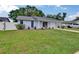 Charming single-story home with a well-manicured lawn, driveway, and white fence at 3733 Mendocino St, New Port Richey, FL 34655