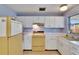 Functional kitchen with white cabinets, classic appliances, and a clean design at 3733 Mendocino St, New Port Richey, FL 34655