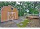 A backyard with a shed, deck, and brick pathway amidst lush greenery at 3906 W San Luis St, Tampa, FL 33629