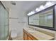 Well-lit bathroom featuring a vanity with a granite countertop and a glass-enclosed shower at 3906 W San Luis St, Tampa, FL 33629